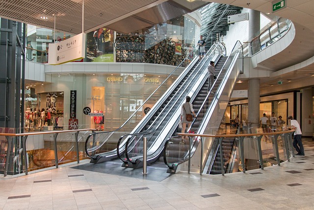 The inside of a shopping mall, showing an escalator.